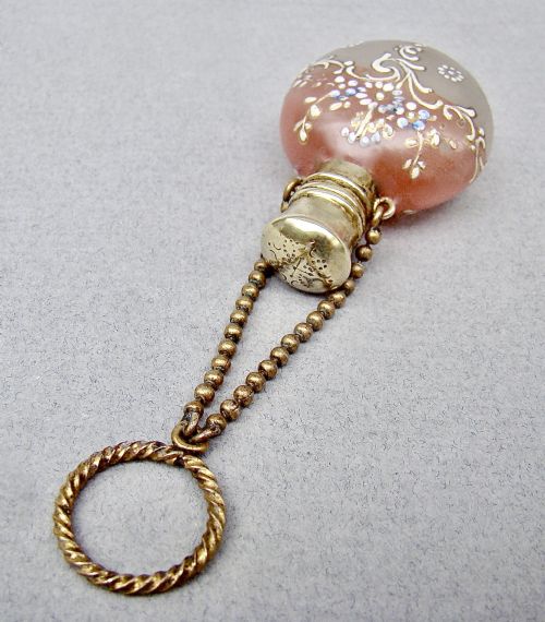 fig 2. A nineteenth-century French satin glass chatelaine scent bottle decorated with hand-applied enamel scrolls and flowers, fitted with a gilded metal cap and chain.