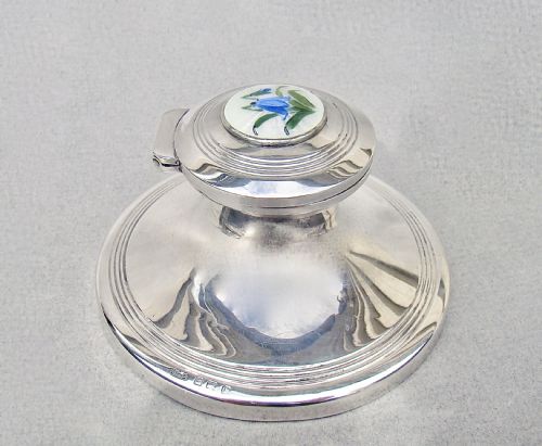 fig 1. A circular Edwardian sterling silver capstan inkwell featuring a hinged lid inset with a floral guilloche enamel medallion.