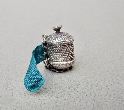 fig 1. A drum-shaped Georgian silver tape measure with an engine-turned honeycomb texture and attached suspension chain.