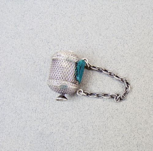 fig 2. A drum-shaped Georgian silver tape measure with an engine-turned honeycomb texture and attached suspension chain.