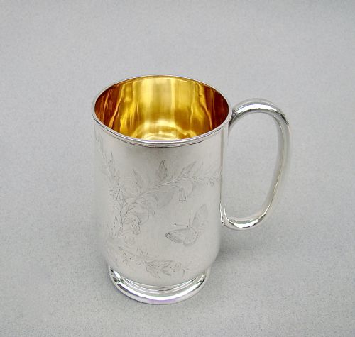 fig 1. A Victorian sterling silver christening mug featuring a gilt interior and engraved Aesthetic Movement decoration of a bird on a blossom branch.