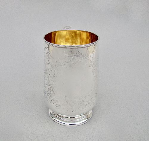 fig 2. A Victorian sterling silver christening mug featuring a gilt interior and engraved Aesthetic Movement decoration of a bird on a blossom branch.