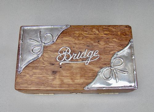 fig 1. An Edwardian oak box featuring sterling silver ribbon corner mounts and a silver script word reading Bridge on the lid.