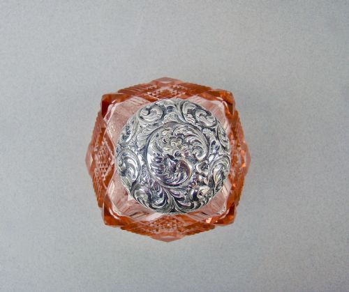 fig 3. A Victorian pale salmon pink cut glass scent bottle featuring a hand-chased sterling silver top.