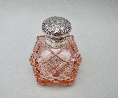 fig 1. A Victorian pale salmon pink cut glass scent bottle featuring a hand-chased sterling silver top.