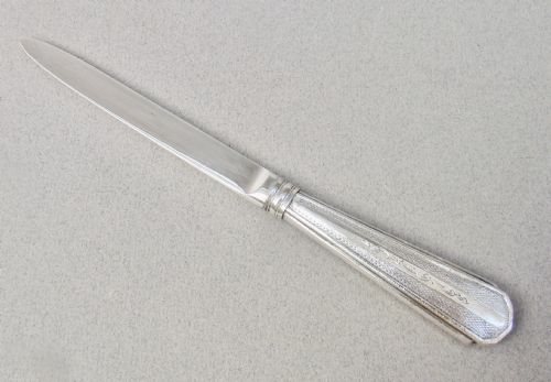 fig 1. An Art Deco sterling silver letter opener featuring a tapered blade with English hallmarks and a pink guilloche enamel handle.