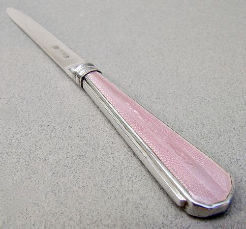 fig 2. An Art Deco sterling silver letter opener featuring a tapered blade with English hallmarks and a pink guilloche enamel handle.