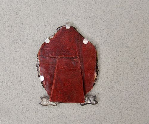 fig 3. A miniature oval sterling silver photo frame featuring a crowned crest, a laurel leaf frame, and a commemorative banner.