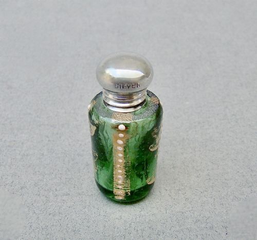 fig 1. A miniature green glass scent bottle featuring painted gilt and enamel dot decoration, topped with a rounded silver screw cap stamped with SILVER.