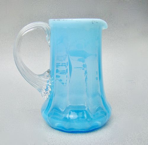 fig 1. A light blue opalescent glass cream jug featuring hand-painted enamel flora and dragonfly motifs with an applied clear glass handle.