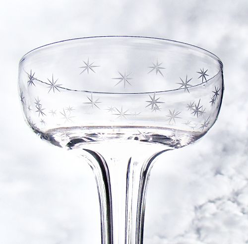 fig 1. A pair of clear Victorian glass champagne coupes featuring star-etched patterns across the bowls and slender hollow stems.