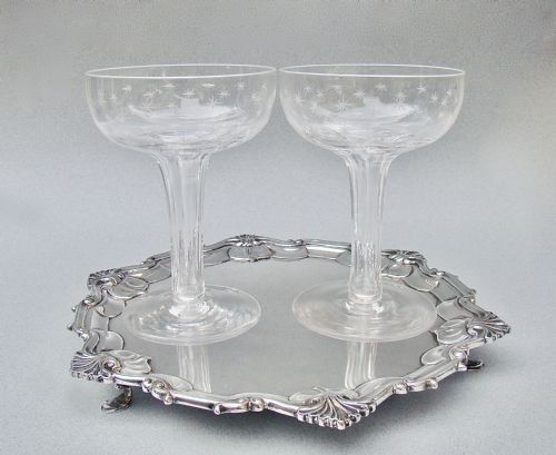 fig 2. A pair of clear Victorian glass champagne coupes featuring star-etched patterns across the bowls and slender hollow stems.