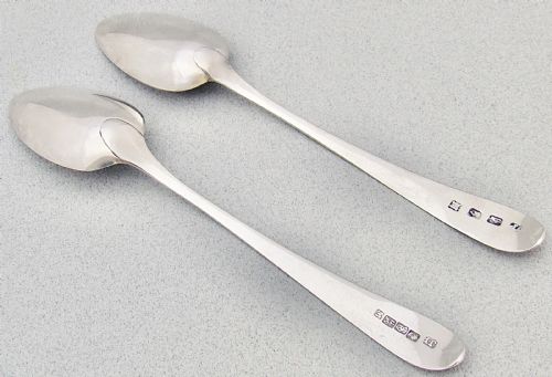 fig 2. A pair of Georgian Irish sterling silver dessert spoons featuring bright-cut engraved stems with starburst and floral detailing.