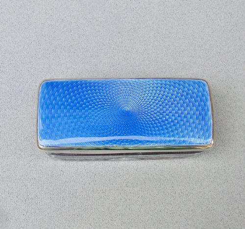 fig 3. An Art Deco rectangular cut glass dressing table jar with a sterling silver lid featuring vibrant blue guilloche enamel.