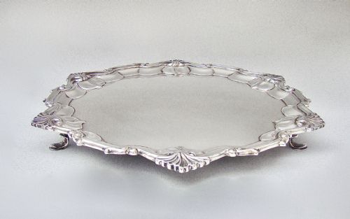 fig 1. A circular late Victorian silver-plated salver featuring a moulded, scalloped rim decorated with shell motifs.