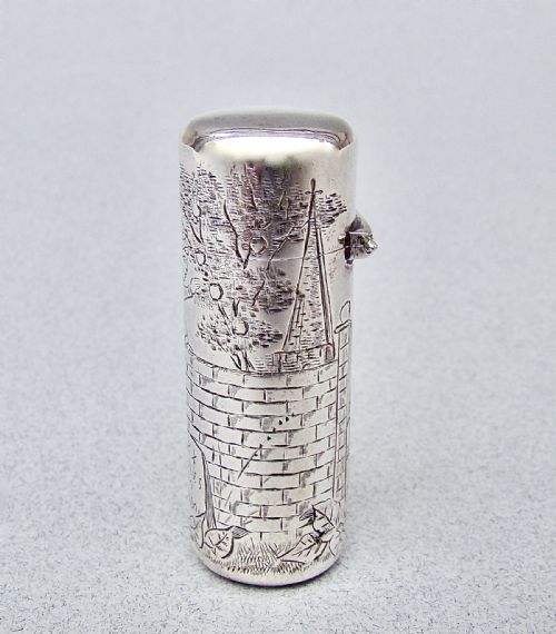 fig 2. A cylindrical Victorian sterling silver scent bottle decorated with an engraved illustration of a child on a brick wall near a milestone.
