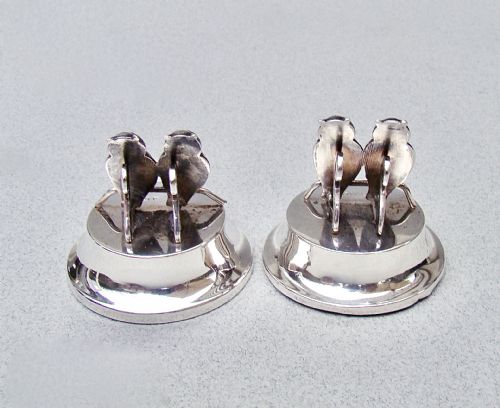 fig 1. A pair of Edwardian sterling silver owl-form menu holders positioned inside a fitted black presentation case lined with blue velvet and beige silk.