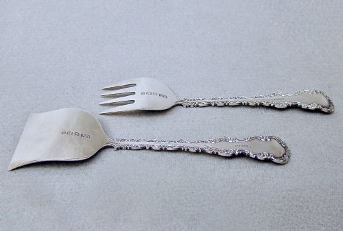 fig 2. A cased set of two late Victorian sterling silver sardine servers featuring engraved scroll decorations resting inside an open fitted presentation box.