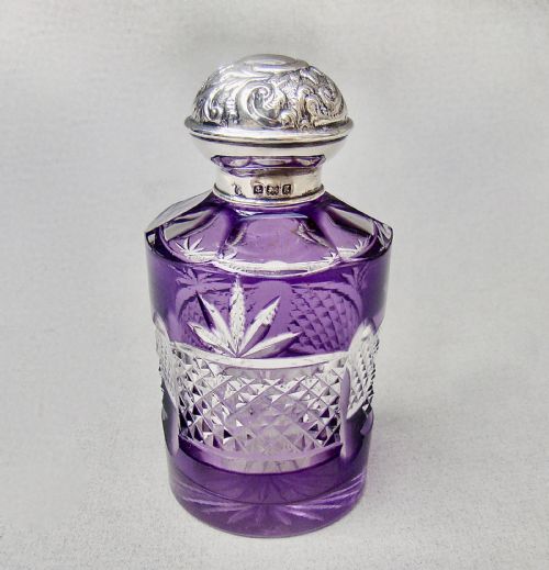 fig 1. An Edwardian cut-to-clear amethyst glass scent bottle featuring diamond facets and an embossed sterling silver cap.