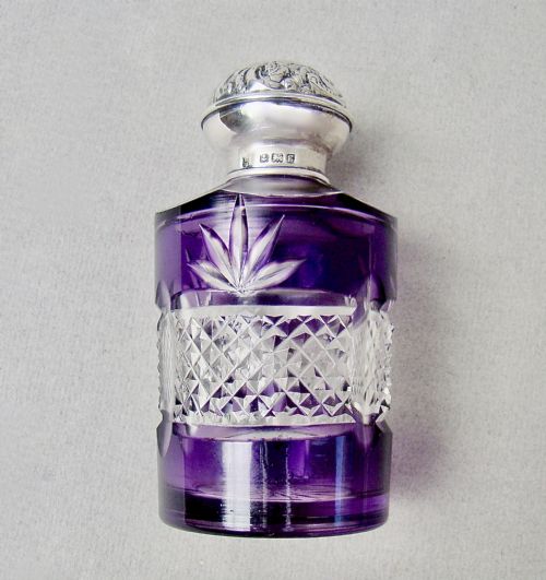 fig 2. An Edwardian cut-to-clear amethyst glass scent bottle featuring diamond facets and an embossed sterling silver cap.