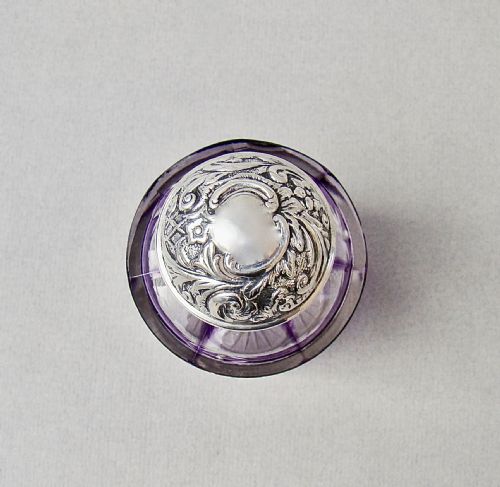 fig 3. An Edwardian cut-to-clear amethyst glass scent bottle featuring diamond facets and an embossed sterling silver cap.