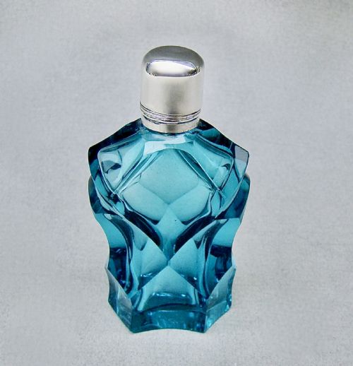 fig 1. A Victorian sliced-cut teal glass scent bottle featuring geometric facets and a polished silver cap.