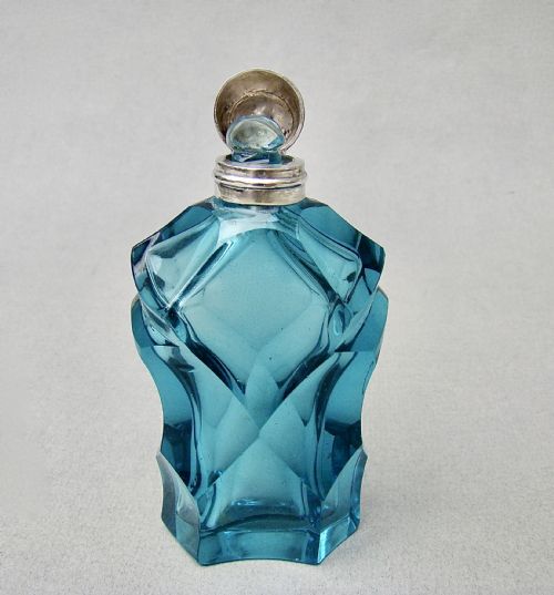 fig 2. A Victorian sliced-cut teal glass scent bottle featuring geometric facets and a polished silver cap.
