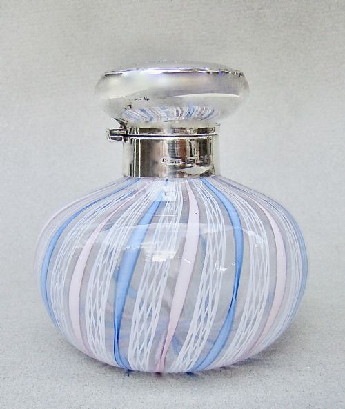 fig 1. An Edwardian squat glass scent bottle featuring blue, white, and pink latticino stripes topped with a polished silver cap.