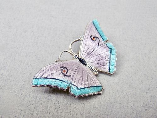 fig 1. An Art Deco sterling silver and guilloche enamel butterfly brooch featuring lilac and turquoise wings with delicate engine-turned patterns.