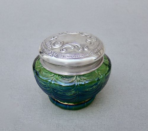 fig 1. An antique green iridescent glass trinket pot with an embossed sterling silver lid.