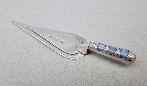 fig 1. A Victorian sterling silver trowel-shaped bookmark with an agate handle inside a red leather Harrods case.