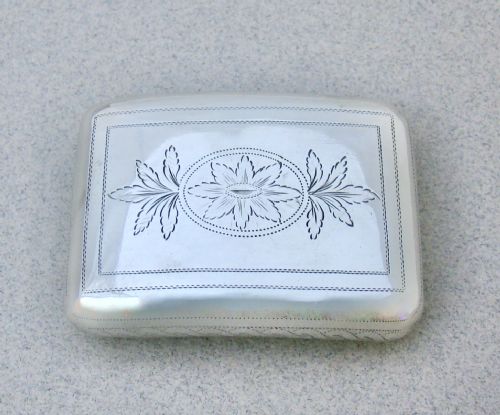 fig 2. A rectangular Georgian sterling silver snuff box featuring hand-engraved oak leaf motifs, a central monogram cartouche, and a curved profile.
