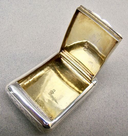 fig 3. A rectangular Georgian sterling silver snuff box featuring hand-engraved oak leaf motifs, a central monogram cartouche, and a curved profile.