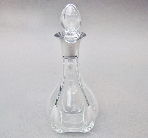 fig 2. An Art Deco clear glass oil bottle with a silver-mounted rim, stopper, and integral handle.