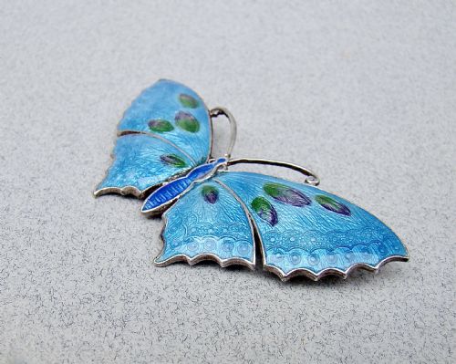 fig 1. A Scandinavian sterling silver butterfly brooch featuring bright blue guilloche enamel wings with green and purple accents.