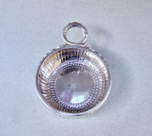 fig 2. A shallow early 19th-century French silver wine taster featuring fluted gadrooning, punchwork detailing, engraved rim lettering, and a ring handle.
