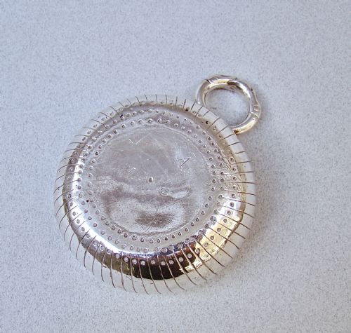 fig 3. A shallow early 19th-century French silver wine taster featuring fluted gadrooning, punchwork detailing, engraved rim lettering, and a ring handle.