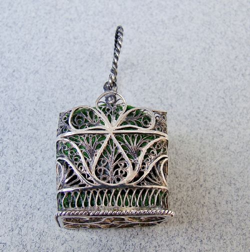 fig 2. A Georgian silver filigree basket pin cushion with a twisted wire handle and a green velvet cushion pad.