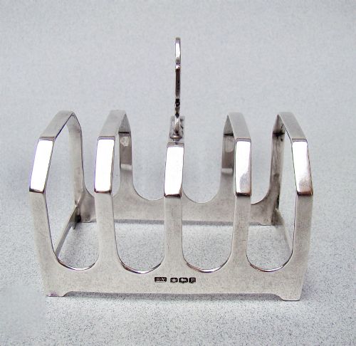 fig 1. An Art Deco solid silver four-slice toast rack featuring angular dividers and a geometric central handle.