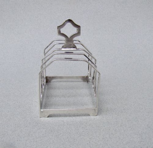 fig 2. An Art Deco solid silver four-slice toast rack featuring angular dividers and a geometric central handle.