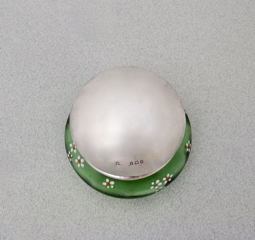 fig 2. A small green glass jar decorated with white enamel flowers and topped with a hallmarked sterling silver cap.