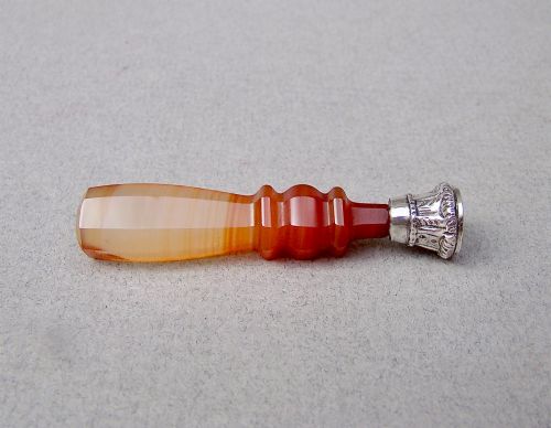 fig 1. A Victorian desk seal featuring a carved red and cream banded agate handle with an engraved silver mount.