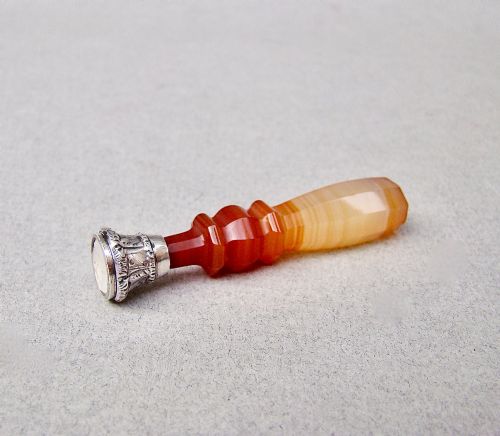 fig 2. A Victorian desk seal featuring a carved red and cream banded agate handle with an engraved silver mount.