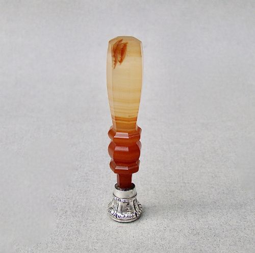 fig 3. A Victorian desk seal featuring a carved red and cream banded agate handle with an engraved silver mount.