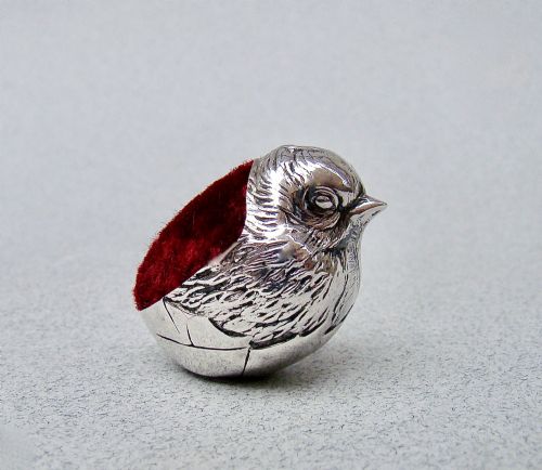 fig 1. An Edwardian sterling silver pin cushion formed as a hatching chick emerging from an eggshell with a red velvet insert.