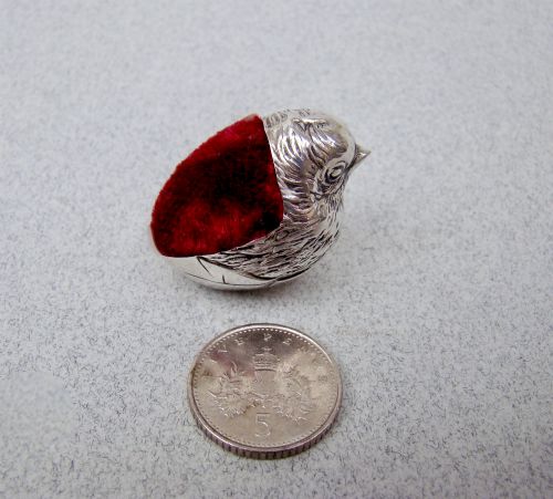 fig 2. An Edwardian sterling silver pin cushion formed as a hatching chick emerging from an eggshell with a red velvet insert.