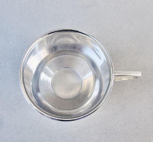 fig 2. A sterling silver Art Deco christening mug with a flared body, geometric angular handle, and stepped pedestal base.