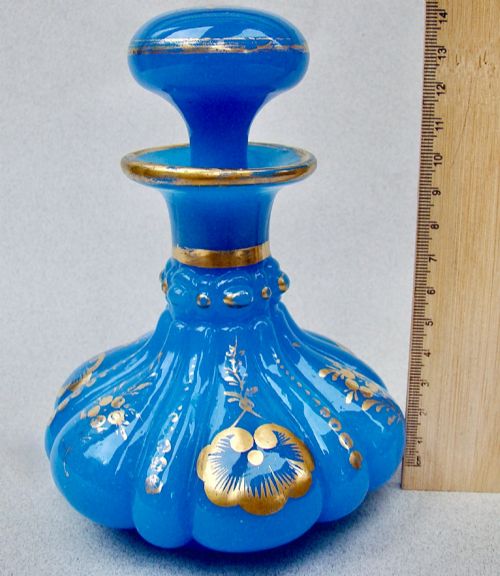 fig 2. A bright blue lobed opaline glass scent bottle with a flared rim, ground glass stopper, and hand-gilded floral motifs.