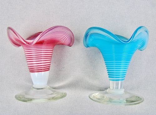 fig 1. A pair of late Victorian opaline glass candlesticks with coiled threaded bodies and wide frilled rims, one in pink and one in turquoise blue.
