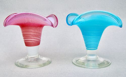 fig 2. A pair of late Victorian opaline glass candlesticks with coiled threaded bodies and wide frilled rims, one in pink and one in turquoise blue.